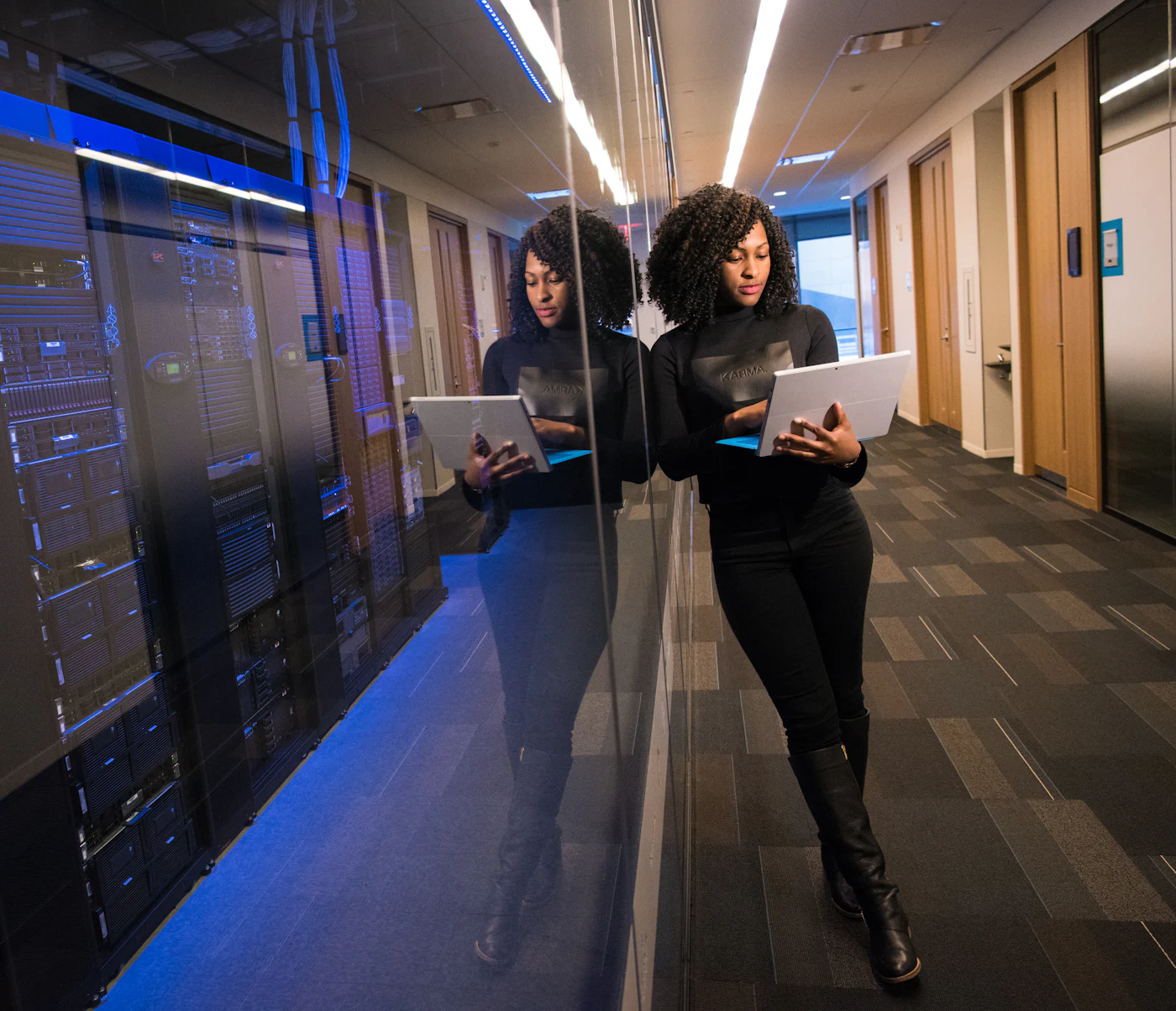 Technician with a laptop beside server racks in a data centre